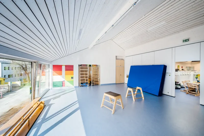 Architekturfotografie – Bewegungsraum im Kindergarten Weitersfeld mit Turngeräten und blauem Boden