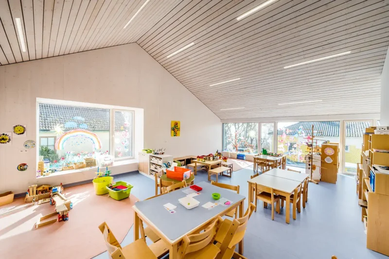 Architekturfotografie – Gruppenraum im Kindergarten Weitersfeld mit Holzdecke und kindgerechter Ausstattung