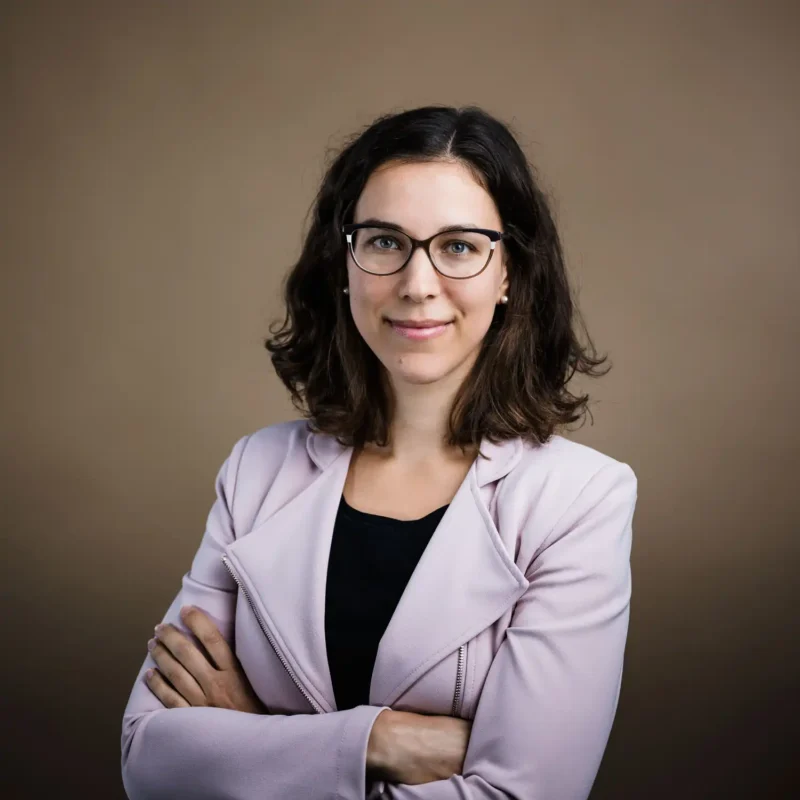 Businessportrait einer Frau mit dunklem Haar, Brille und hellrosa Blazer, BOKU Wien