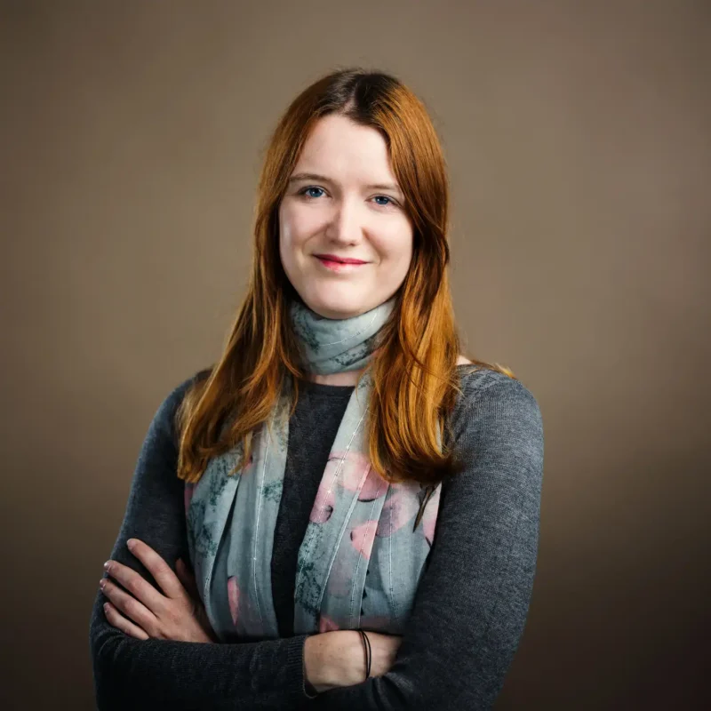 Businessportrait einer Frau mit rotem Haar, grauem Cardigan und floralem Schal, BOKU Wien