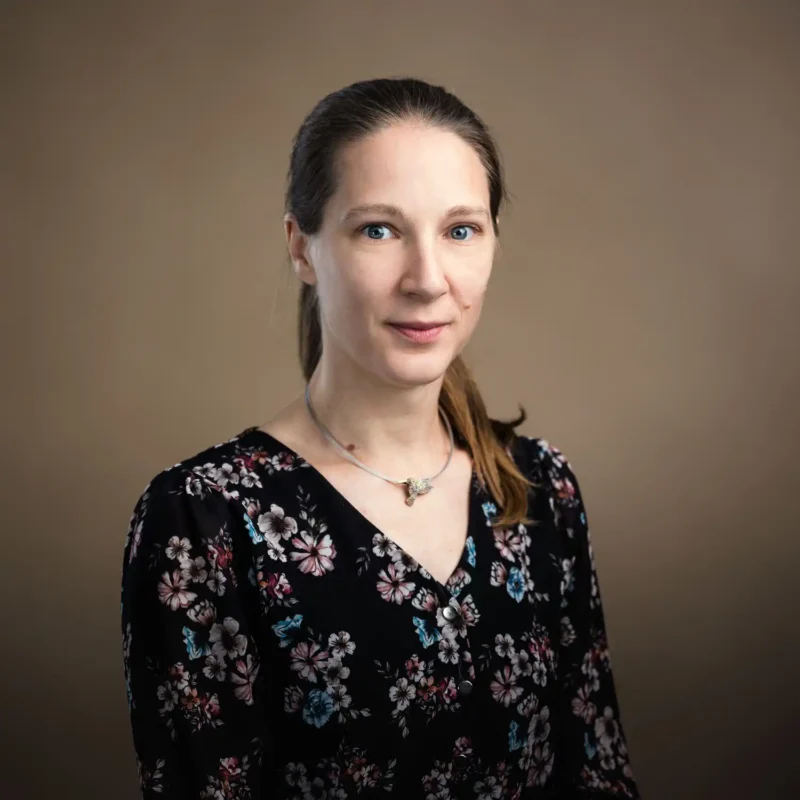 Businessportrait einer Frau mit Pferdeschwanz und schwarzer Blumenbluse, BOKU Wien