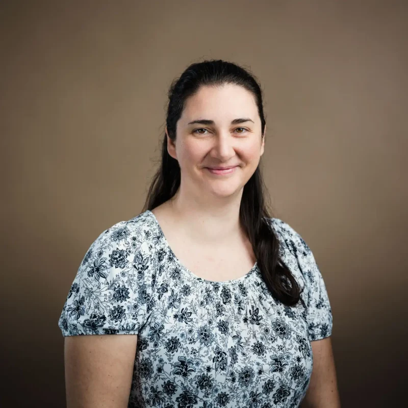 Businessportrait einer Frau mit langen dunklen Haaren in weißem Blumenoberteil, BOKU Wien