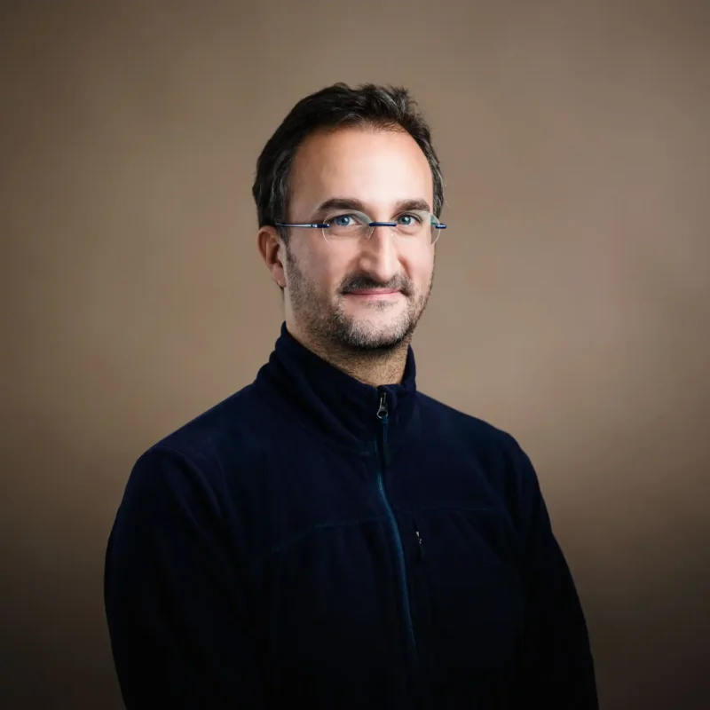 Businessportrait eines Mannes mit dunklem Haar, randloser Brille und dunkelblauer Fleecejacke, BOKU Wien