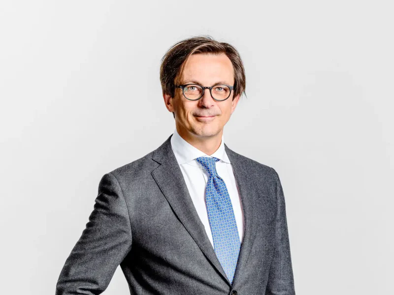 Businessportrait von Michael Stampfer, Geschäftsführer des Wiener Wissenschaftsfonds WWTF, im grauen Anzug mit blauer Krawatte