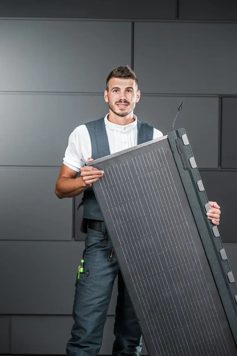 Editorial Portrait von Marvin Bürger mit PREFA Solarpanel vor grauer Fassade in Rheinbach