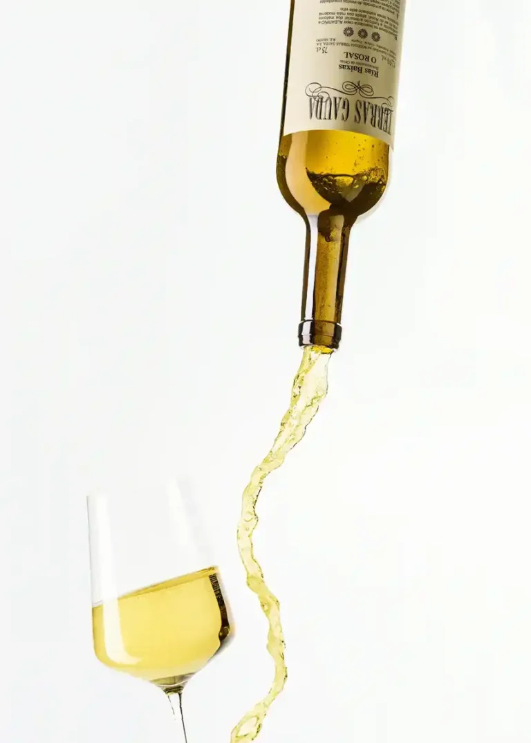 Produktfotografie – Terras Gauda Weißweinflasche mit eingefrorenem Gießstrahl in Weinglas vor weißem Hintergrund